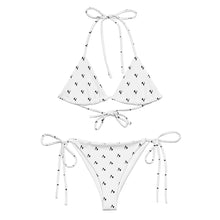 Load image into Gallery viewer, A two-piece string bikini set in white with a small black chevron pattern, featuring a halter top and matching side-tie bottoms, displayed on a solid white background.