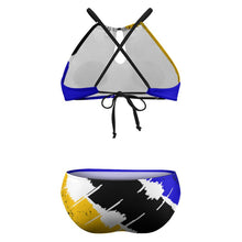 Load image into Gallery viewer, Two-piece bikini set with a bold abstract paint stroke pattern in blue, yellow, black, and white. The top is a triangle style with black crisscross shoulder straps and a front tie, while the bottom is a low-rise style with a matching abstract print.